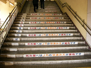 階段の一段おきに「名古屋へはJRの快速みえが便利です」と書かれたプレートが貼られている。