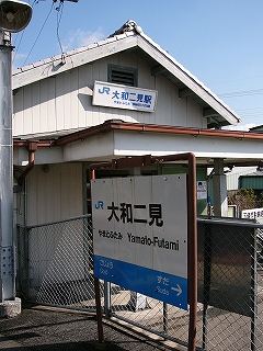 駅舎の妻面に掛かる駅名表示とホームの駅名標。