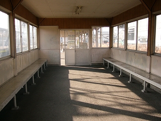 両側にはサッシの窓が隙間なく取り付けられ、その下に白塗りの長い木製の椅子がすえつけられている。